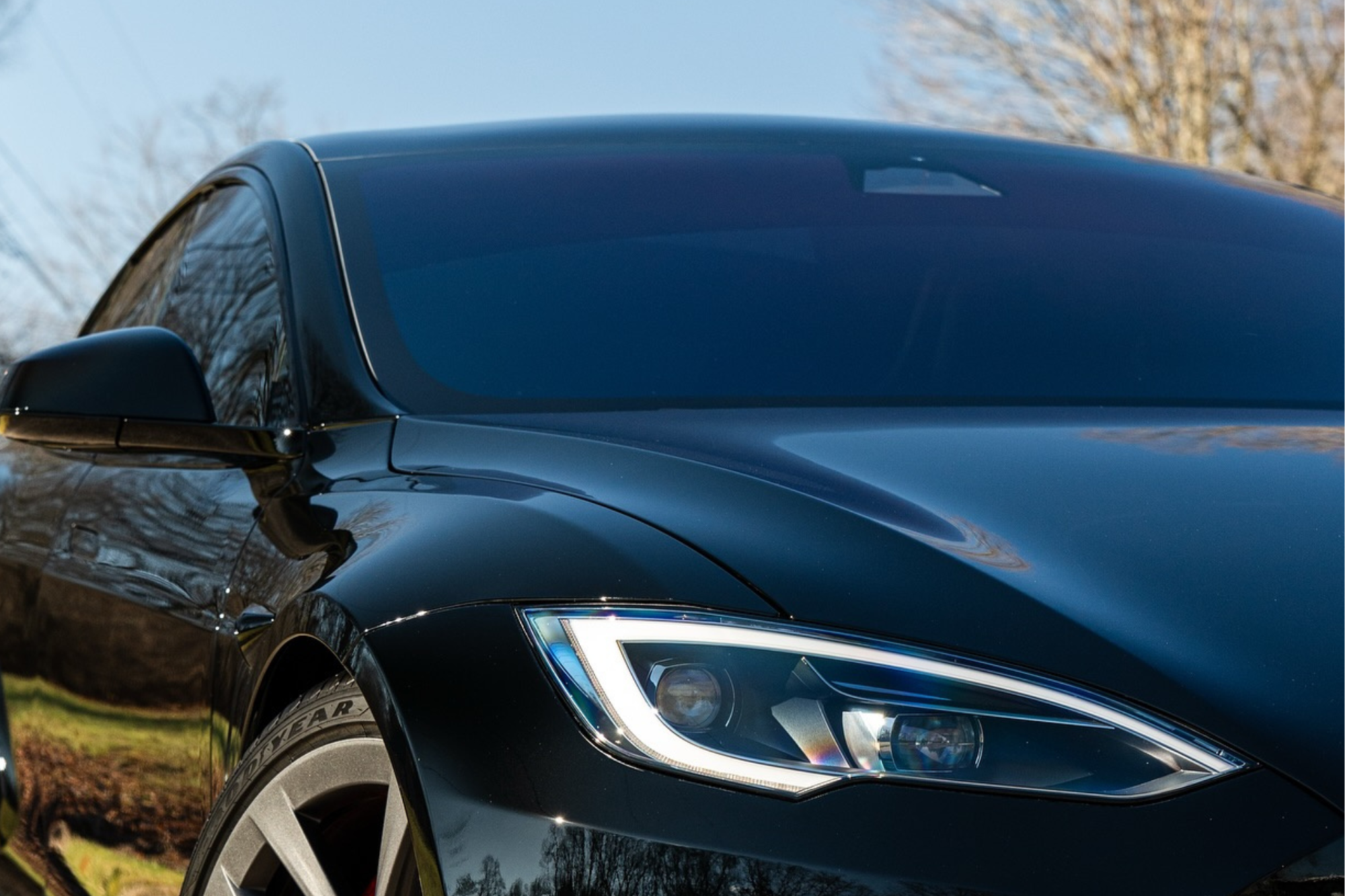 A sleek black Tesla car showcasing its modern front end design and distinctive features.